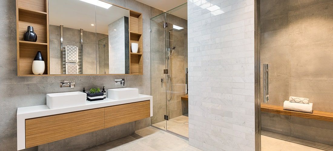 Larger modern bathroom with wooden-effect furniture, twin sinks and a shower enclosure.