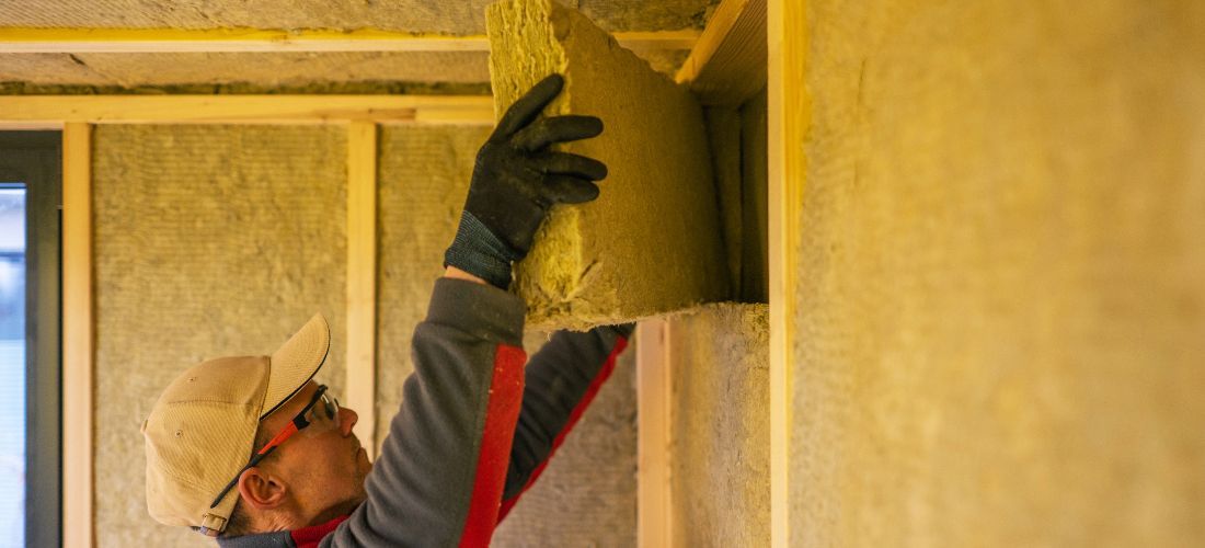 contractor installing insulation in shed