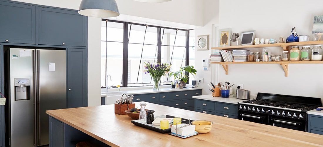 Stylish kitchen with large island and blue cabinets.