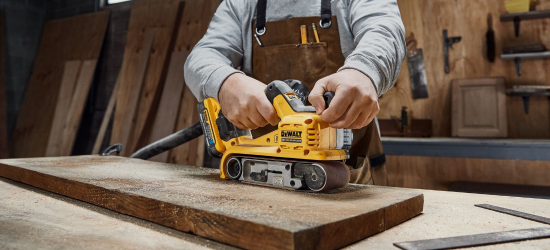 Carpenter using belt sander.