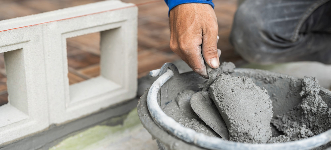 Construction worker using cement on property