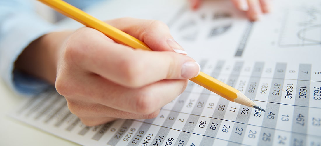 Accountant with yellow pencil checking data.