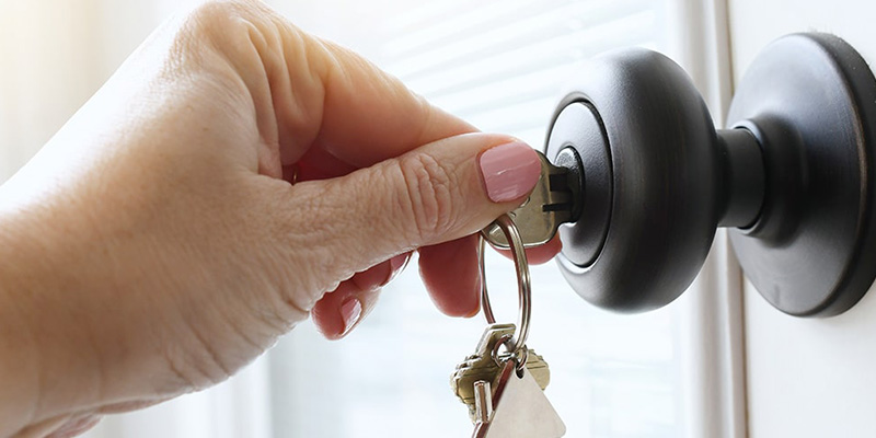 Close-up of homeowner unlocking front door.