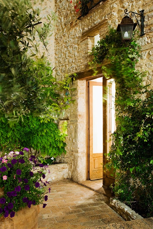 bright front garden illuminated by light coming from open front door.