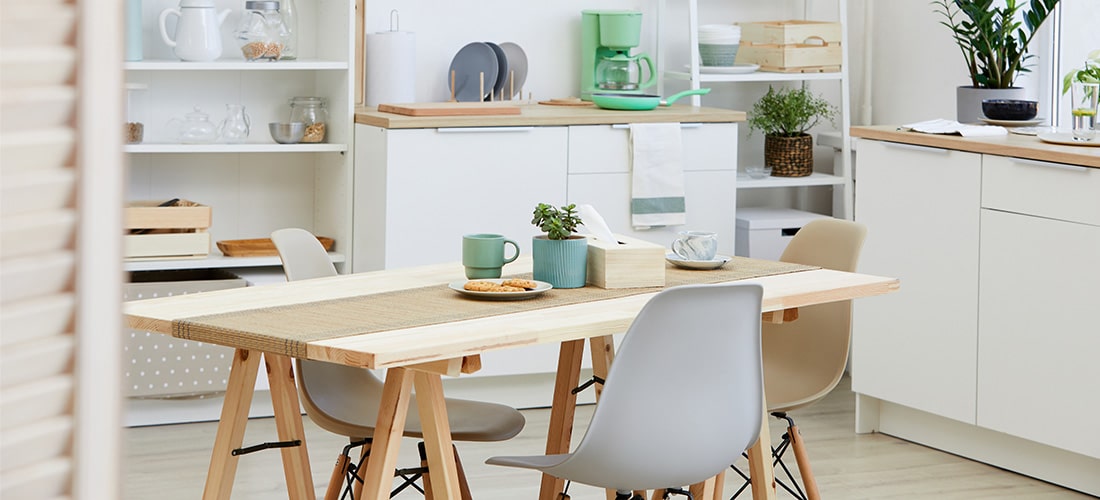 Tidy medium-sized kitchen with wood-effect counter tops and 4-seater table.