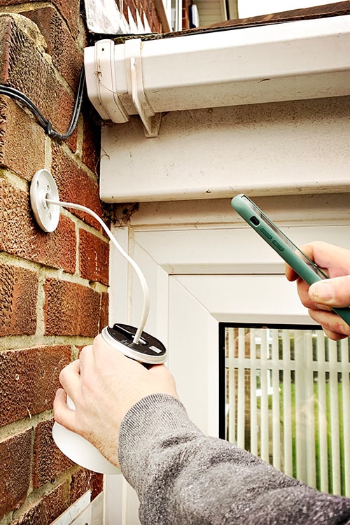 Man using smart phone to register a google nest.