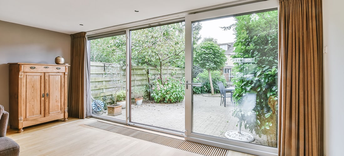 Large paned sliding door leading to clean garden.