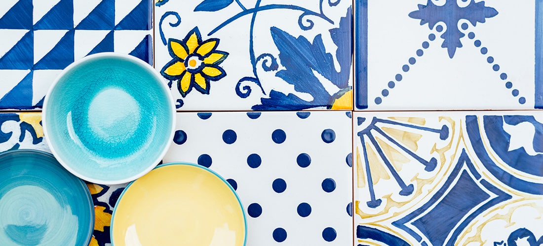 Blue and yellow bowls on top of bright patterned tiles.