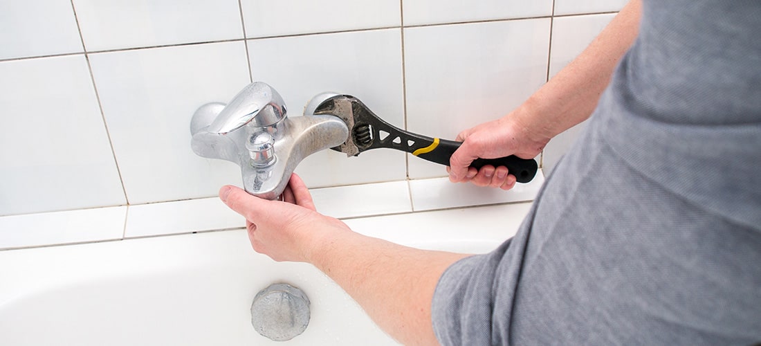 Plumber repairing bath faucet.