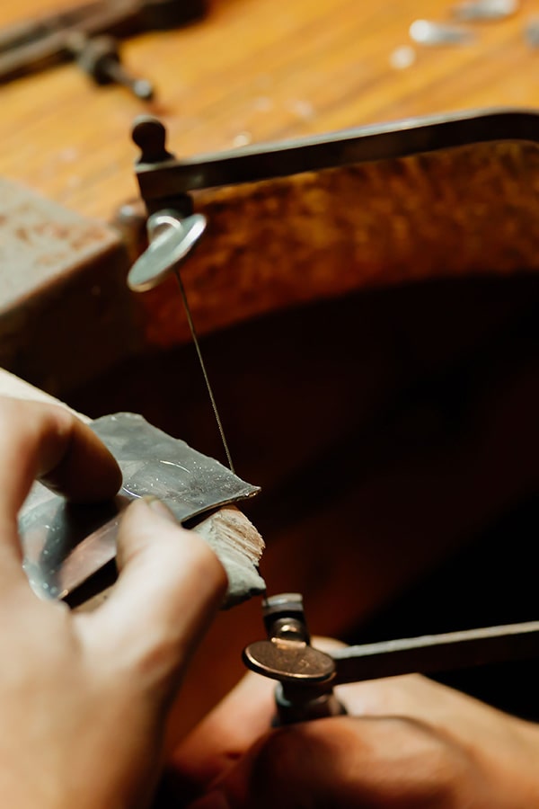 Wood worker cutting a fine angle with a coping saw.